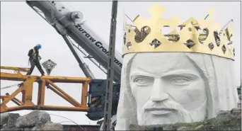  ?? ASSOCIATED PRESS ?? Workers struggling against wind to assemble a crane that is to lift 32-ton head and shoulders to top a giant concrete and metal statue of Jesus in Swiebodzin, western Poland, in 2010. The 108 feet statue is to be the world’s tallest and is supposed to attract pilgrims and boost business in the town.