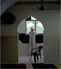  ?? AP ?? A Muslim man speaks on his mobile phone inside a mosque in Colombo, Sri Lanka. Moslems face continuing pressure after the deadly Easter Bombing attacks.