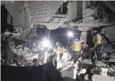  ?? — AFP ?? Rescue workers known as White Helmets inspect the rubble of a building during a search for survivors following Syrian government forces air strikes in the rebel town of Orum al Kubra, in the northern province of Aleppo, late on Friday.