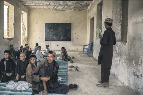  ?? Stefanie Glinski ?? Children attend a lesson at Panjwayi district’s Shahid Niamatulla­h Primary School, which has 128 pupils on its register