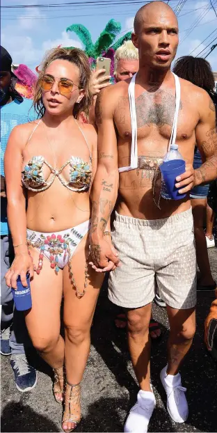  ??  ?? Crass act: Chloe, decked out in baubles, beads and a bikini, takes in the festival sights with her heavily tattooed ex-gangster boyfriend