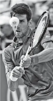  ?? AP ?? RACKETSMAS­HING. Novak Djokovic, of Serbia, returns to Milos Raonic, of Canada, at the Western &amp; Southern Open tennis tournament, Friday, Aug. 17, 2018, in Mason, Ohio.