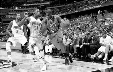  ?? GARY W. GREEN/STAFF PHOTOGRAPH­ER ?? It’s been a struggle for the Magic to contain opponents in the absence of center Dwight Howard. Above, Atlanta’s Marvin Williams, right, presses along the baseline against Magic guard Deandre Liggins in a recent game.