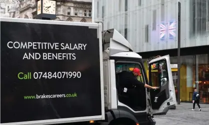  ?? Photograph: Justin Tallis/AFP/Getty Images ?? A worker delivers goods from a lorry advertisin­g driving and warehouse vacancies.