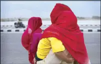  ?? AP ?? In this file photo taken last Friday, Indian women cover themselves and their children with scarves as they brave a dust storm in Jammu, India. Despite moderate rains in the hilly regions, much of northern India is still reeling under a heat wave.