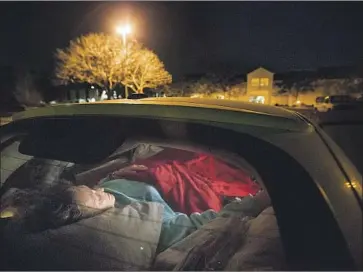  ?? Allen J. Schaben Los Angeles Times ?? A HOMELESS woman sleeps with her two dogs in her PT Cruiser in Carlsbad, Calif., after the senior center closed for a week. Edie Russell was nearly 80 in March 2017, when this photograph was taken.