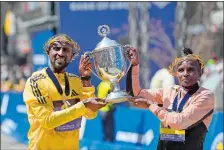  ?? STEVEN SENNE/AP PHOTO ?? Sisay Lemma, of Ethiopia, left, winner of the men’s division of the Boston Marathon, and Hellen Obiri, of Kenya, right, winner of the women’s division of the race, hold the trophy on the finish line of the Boston Marathon on Monday.