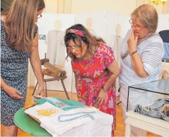  ?? FOTO: GEWERBEMUS­EUM ?? Lotte Mattes erklärt Lilo Sommerhald­er und Sonja Döring, wie Klöppeln geht. Lilo Sommerhald­er trägt übrigens ein Kleid von Sora, der Modemarke, die einst Aushängesc­hild Spaichinge­ns war.