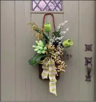  ??  ?? This willow basket is filled with: green and white check ribbon, philo leaf, large green tulips, cream lavender stem, yellow berry spray, pink berry spray, mini green tulip bunch, purple long seed stem. (TNS/Nell Hills)