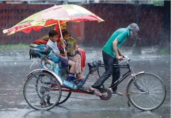  ?? — Reuters ?? A woman and her children ride in a rickshaw during heavy rains in Chandigarh on Monday.