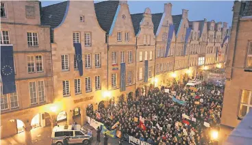  ?? FOTO: DPA ?? Demonstran­ten stehen auf dem Prinzipalm­arkt in Münster. Im nahegelege­nen Rathaus findet der Neujahrsem­pfang des Kreisverba­ndes der AfD Münster mit der Bundesvors­itzenden Frauke Petry statt.