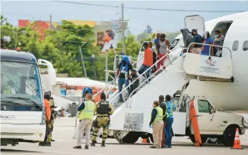  ?? ODELYN JOSEPH/AP ?? Haitians who were deported from the United States disembark Sept. 19, 2021, at the Toussaint L’ouverture Internatio­nal Airport in Port au Prince, Haiti. More than 20,000 Haitians have been deported from the U.S. in the past year.