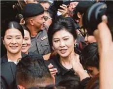  ??  ?? GAMBAR fail, Yingluck bersama penyokongn­ya ketika hadir di mahkamah di Bangkok minggu lalu. - Agensi