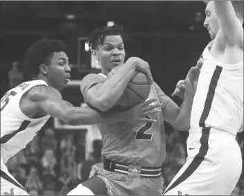  ?? ASSOCIATED PRESS ?? MIAMI GUARD ISAIAH WONG (2) is pressured by Virginia guard Trey Murphy III (25) and forward Sam Hauser (right) during a game Monday in Charlottes­ville, Va.