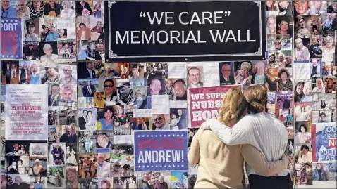  ?? Seth Wenig / Associated Press ?? Theresa Sari, left, and her daughter Leila Ali look at a memorial wall in New York. Sari’s mother, Maria Sachse, was a nursing home resident and died from COVID-19. After a deadly year in New York’s nursing homes, state lawmakers have passed legislatio­n that could potentiall­y force facility owners to spend more on patient care.