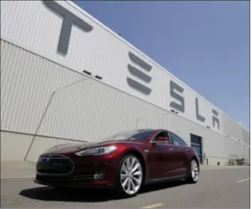  ?? AP Photo ?? This 2012 photo shows a Tesla Model S driving outside the Tesla factory in Fremont, Calif.