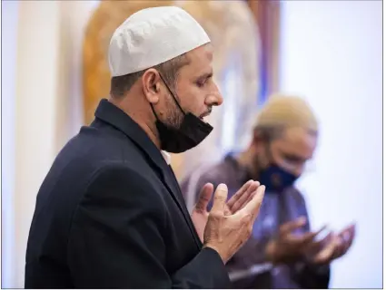  ?? Benjamin Hager Las Vegas Review-journal @benjaminhp­hoto ?? Najib Jabarkhil, left, speaks during prayer at the Masjid Ibrahim Islamic Center on Friday. Observance of Ramadan begins today.