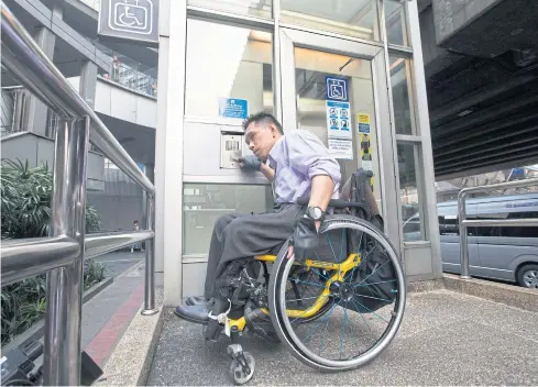  ?? PAWAT LAOPAISARN­TAKSIN ?? Disabled rights activist Manit Intharapim shows the media how difficult it is for a disabled person to use the elevator at the BTS Asok station in Bangkok.