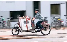  ?? FOTO: DPA ?? Mit einem E-lastenrad lässt sich auch schwere Ladung wie eine Waschmasch­ine transporti­eren.