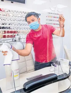  ?? Pictures: PA. ?? Top and above: Bau Van Pham, manager of Nails and Spa on Croall Place, Edinburgh, cleans and makes preparatio­ns before the salon reopens today.