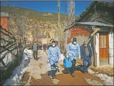  ??  ?? Dr. Yasin Kaya (center) and Duran (left), members of the Koyulhisar Public Health Center vaccinatio­n team, walk to vaccinate 85-year-old Ibrahim Yigit at his house in the village of Gumuslu.