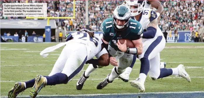  ?? | JEFFGROSS/ GETTY IMAGES ?? Eagles quarterbac­k Carson Wentz injured his left knee diving into the end zone late in the third quarter. The touchdown was negated by a penalty.