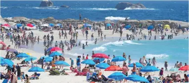  ?? PICTURE: HENK KRUGER/AFRICAN NEWS AGENCY/ANA ?? FESTIVE: Camps Bay main beach was covered in blue and red umbrellas as hundreds of people enjoyed the warm weather.