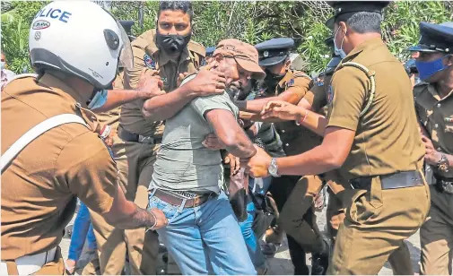  ?? ?? Sri Lankan police officers detain a protester in Colombo, Sri Lanka in June 2020
