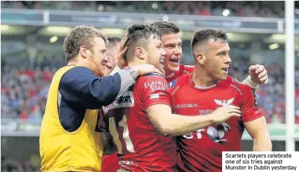  ??  ?? Scarlets players celebrate one of six tries against Munster in Dublin yesterday