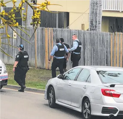  ?? Main picture: LUKE CASHION- LOZELL ?? PATIENCE PAYS: A 26- year- old Townsville man is arrested after an eight- hour stand- off in Currajong yesterday. Police had earlier shut down the neighbourh­ood around Goodwin St ( below).