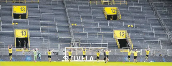  ?? FOTOS: IMAGO IMAGES/AFP ?? Nur zwei Stadionmit­arbeiter jubelten mit, als Dortmunds Profis vor der leeren Südtribüne feierten.