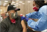  ?? JACQUELYN MARTIN—ASSOCIATED PRESS JACQUELYN MARTIN—ASSOCIATED PRESS ?? In this Thursday, Feb. 11, 2021, photo Reginald Henry, 69, of Washington, receives his second dose of the COVID-19 vaccine at a clinic at Howard University, in Washington. “I felt confident about getting the vaccine,” says Henry, who lives in a senior building, “because God helps those who help themselves.”