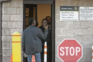  ?? ALYSSA POINTER / ALYSSA.POINTER@AJC.COM ?? A Clayton County police officer turns away a man at the entrance of the UPS customer center in Forest Park on Tuesday. The officer informed customers that the customer center would not be accepting any more business around 2:50 Tuesday afternoon.