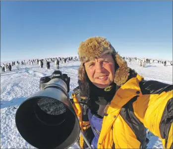  ??  ?? Doug Allan filming an emperor penguin colony and, below, in the Arctic.