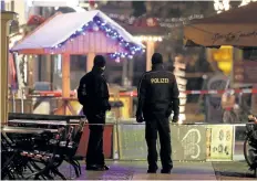  ?? SEAN GALLUP/GETTY IMAGES ?? Police stand in a roped-off area at a Christmas market close to where an explosive device was found earlier in the day on Friday in Potsdam, Germany. According to police the package contained white powder, wires and nails and was left outside a pharmacy.