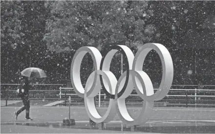  ?? JAE C. HONG/AP ?? Snow falls on the Olympic rings Saturday in Tokyo. The Internatio­nal Olympic Committee has insisted for weeks, and continues to do so, that it plans to go ahead with the Olympics and Paralympic­s as scheduled.