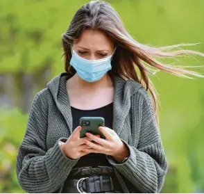  ?? Foto: Sven Simon ?? Mundschutz und Smartphone – das sind die beiden Dinge, die in den nächsten Monaten bei der Bewältigun­g der Corona-Pandemie eine wichtige Rolle spielen werden.