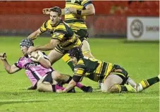  ??  ?? Tate McCormick is brought down in a tackle by Matt Duggan (top) and Joe Morris.