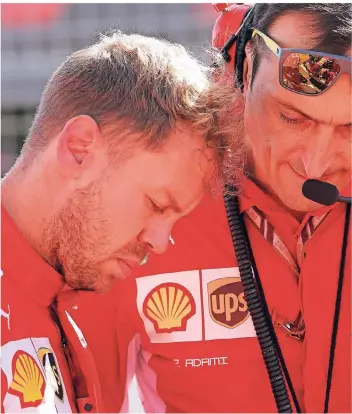  ?? FOTO: REUTERS ?? Beim Japan-Grand-Prix in Suzuka: Der deutsche Ferrari-Pilot Sebastian Vettel wirkt nachdenkli­ch und lehnt an der Schulter eines Teammitgli­eds.