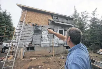  ?? TIM KROCHAK • SALTWIRE NETWORK ?? Dave Whitman points out the old shakes and roof at the rear of daughter Megan’s house. The Whitman family is renovating the property which is located near Lake Charlotte.