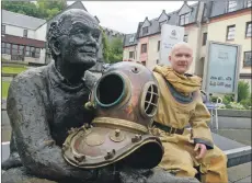  ??  ?? One of the event organisers, Ginge Fullen, takes a break at the ‘Sair Feet’ statue in Fort William. IF F36 DIVERS END OF WEST HIGHLAND WAY 05