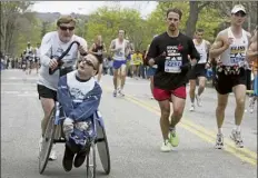  ?? Adam HUNGER / ap file PHOTO ?? Dick hoyt pushes his son Rick through Newton, Mass., during their 25th Boston Marathon together in april 2006.