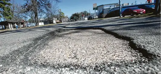  ?? Yi-Chin Lee / Staff photograph­er ?? A pothole lies Friday along 20th Street between Durham and Shepherd drives near the Heights. Last week’s freeze is likely to worsen potholes, experts say.