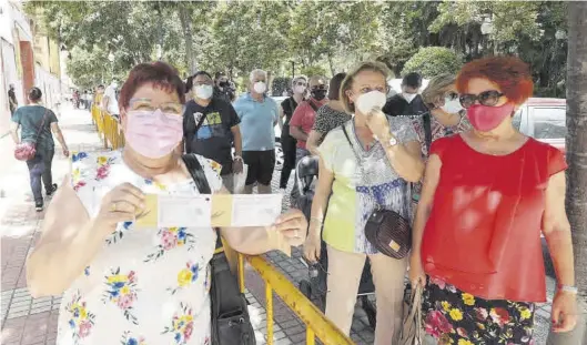  ?? GABRIEL UTIEL ?? Una mujer posa orgullosa con las entradas recién adquiridas para la feria taurina, mientras que la cola daba la vuelta a la manzana, como en ningún otro año.