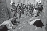  ?? AP/ODED BALILTY ?? Palestinia­ns pray Tuesday as Israeli border police officers stand guard at the Lion’s Gate in Jerusalem’s Old City. Dozens of Muslims have prayed in the street outside a major Jerusalem shrine, heeding a call by clerics not to enter the site until a...