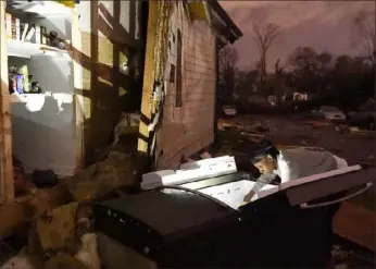  ?? George Walker IV/The Tennessean via AP ?? A woman looks through her refrigerat­or Tuesday after it was ripped out of her home by a tornado in the Elizabeth Park neighborho­od of Nashville, Tenn.