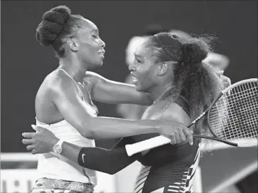  ?? Quinn Rooney Getty Images ?? SISTERS Serena Williams, right, and Venus Williams embrace at the net after Serena’s 6-4, 6-4 victory in the Australian Open final. It was her 23rd major tournament title, passing Steffi Graf for the Open-era record.