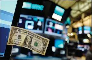  ?? The Associated Press ?? NYSE: In this Dec. 22, 2016, file photo, a dollar bill is taped to a trader’s computer screen at the New York Stock Exchange. The good times keep rolling for fund investors. As of late June 2017, nearly every type of fund logged gains over the three...