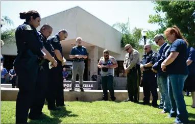  ??  ?? Local public safety officers stand in the middle of a prayer circle in front of the Portervill­e Police Department on Saturday morning to receive a prayer of protection from the community.