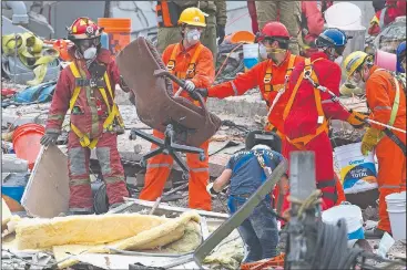  ?? AP/MOISES CASTILLO ?? A rescue worker removes a chair found Saturday at a search and rescue site of a felled office building brought down by a 7.1-magnitude earthquake in Mexico City. As rescue operations stretched into its fifth day, residents throughout the capital have...
